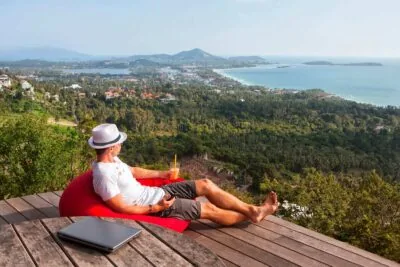 Traveler planning itinerary on terrace with tropical view